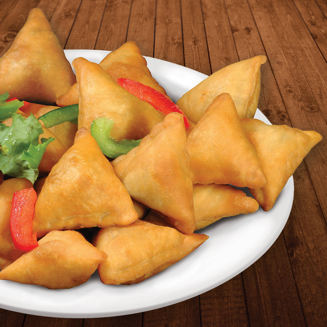 Beef Mini Samosas on plate. They are garnished with red and green bell pepper strips and a small piece of lettuce