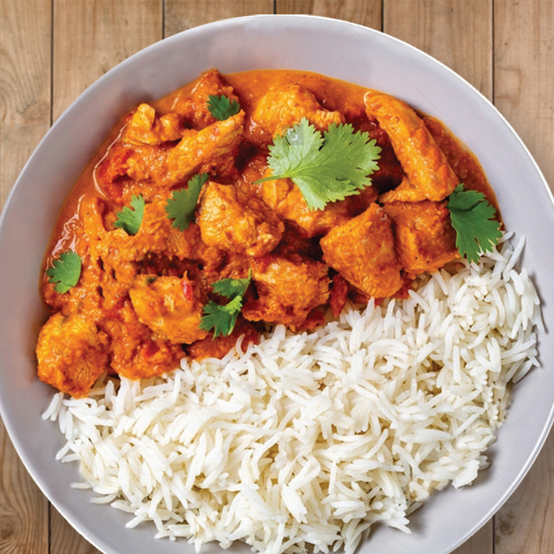 butter chicken on a white plate with basmati rice