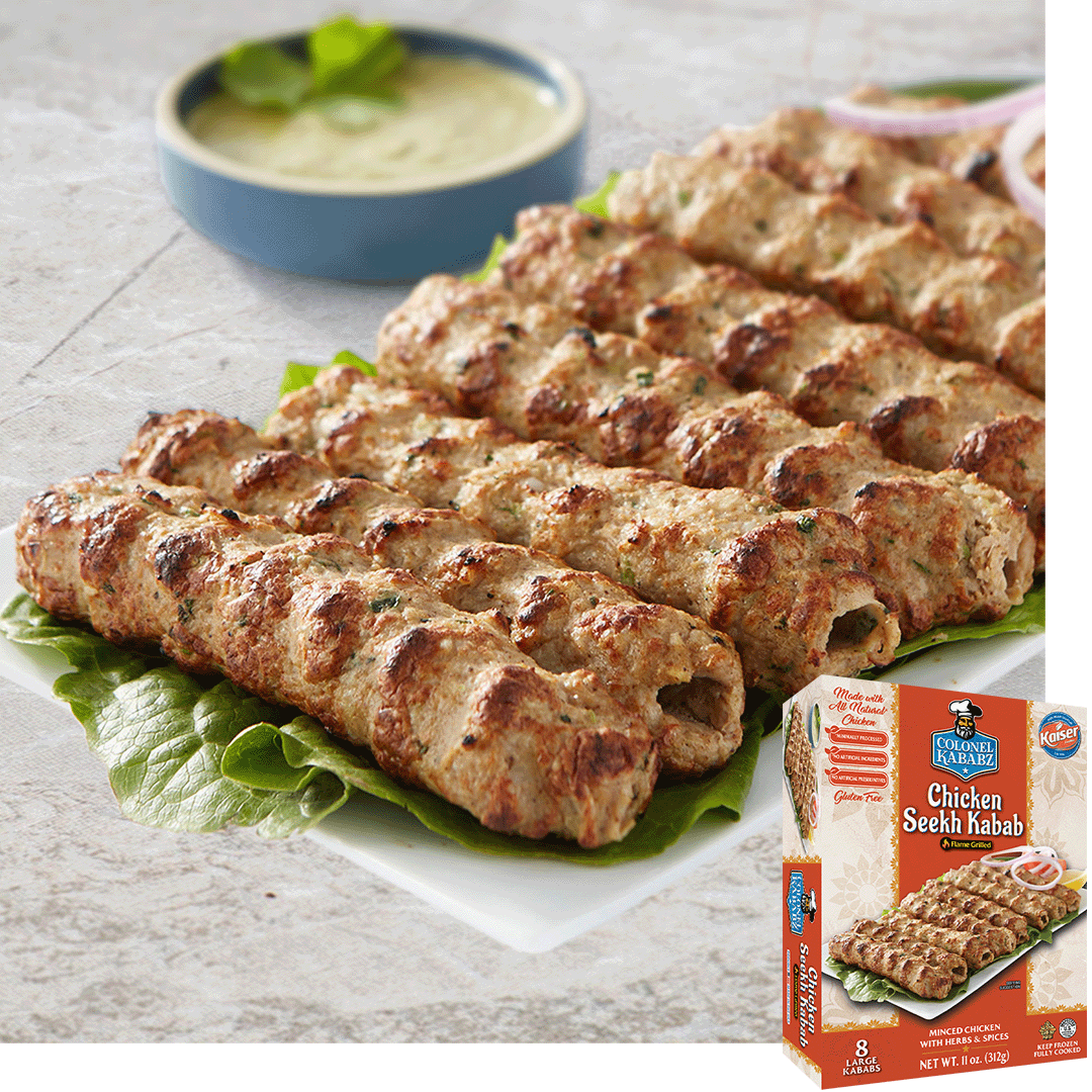 chicken seekh kababs resting leaves of lettuce. The food sits on a rectangular white plate. In the background sits a blow bowl with a beige sauce. In the bottom right hand corner is a picture of the product package