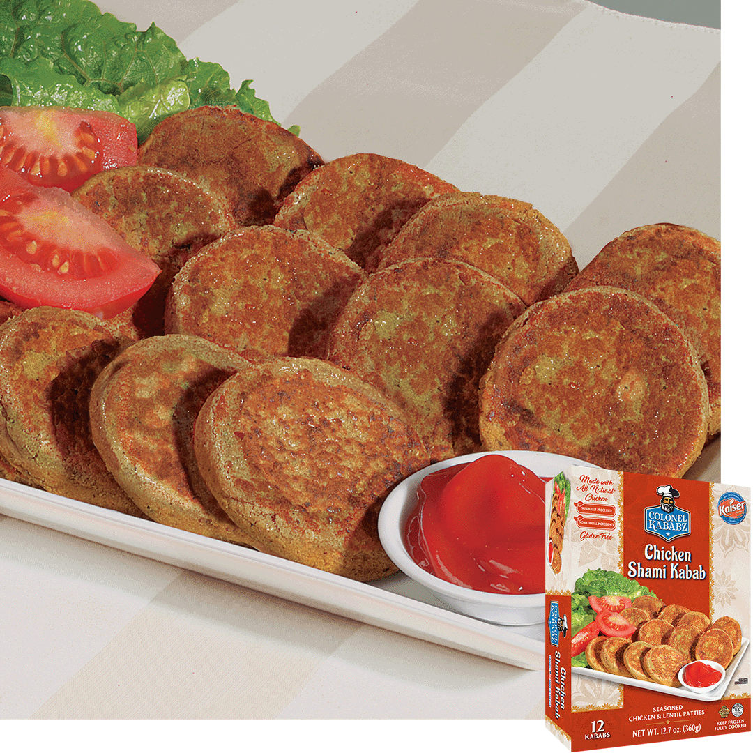 Chicken shami kababs sitting on a rectangular plate. On the back of the plate rest slices of tomato and a leaf of lettuce, on the front of the plate is small bowl with a red condiment. in the bottom right hand corner is a picture of the product package