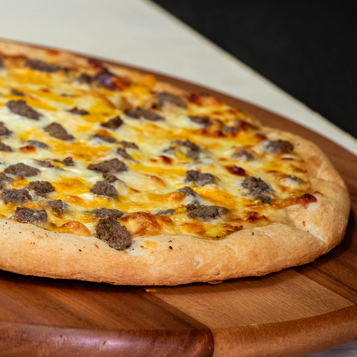 Midamar halal seasoned beef topping cooked into a pizza, the pizza rests on a round wooden tray